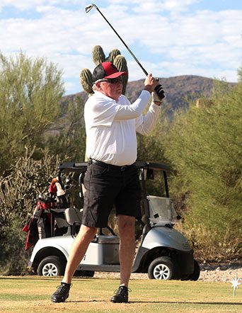 golfer watches ball after teeing off