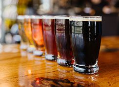 beers lined up on a table from dark to light
