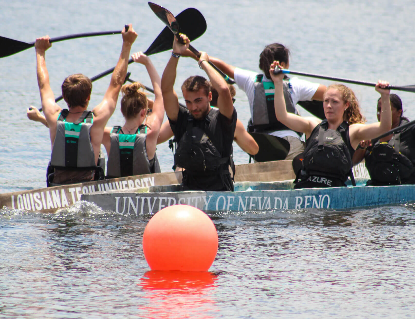 canoe team holding up paddles