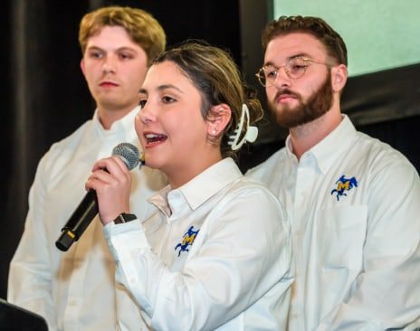 Student speaking into a microphone at a competition