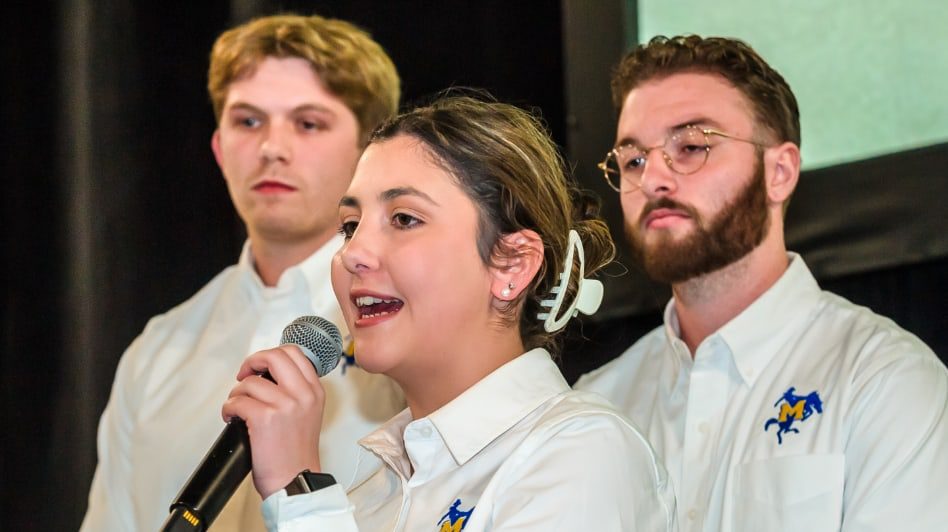 Student speaking into a microphone at a competition