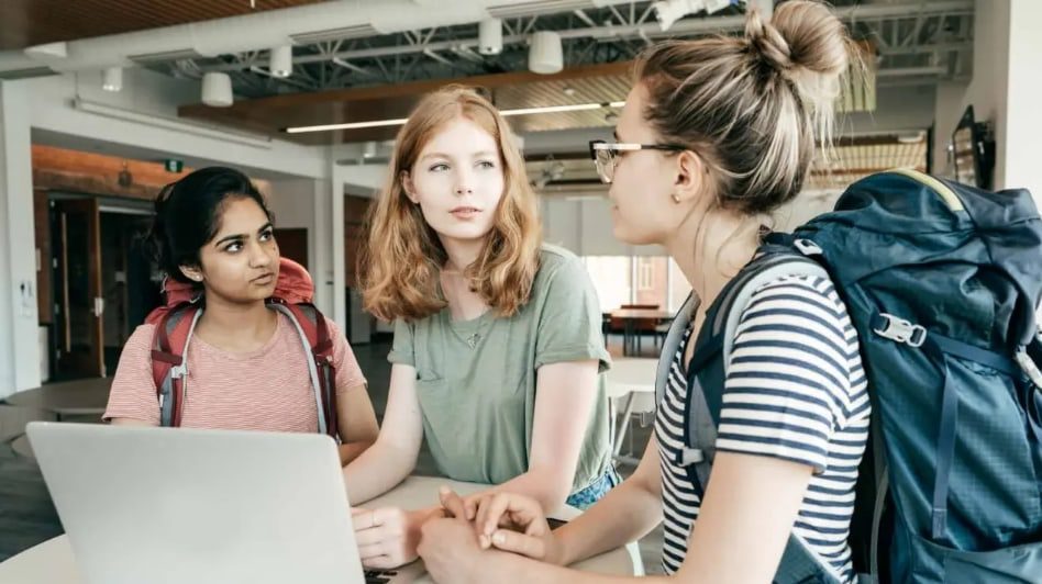 High school students in a discussion around a laptop