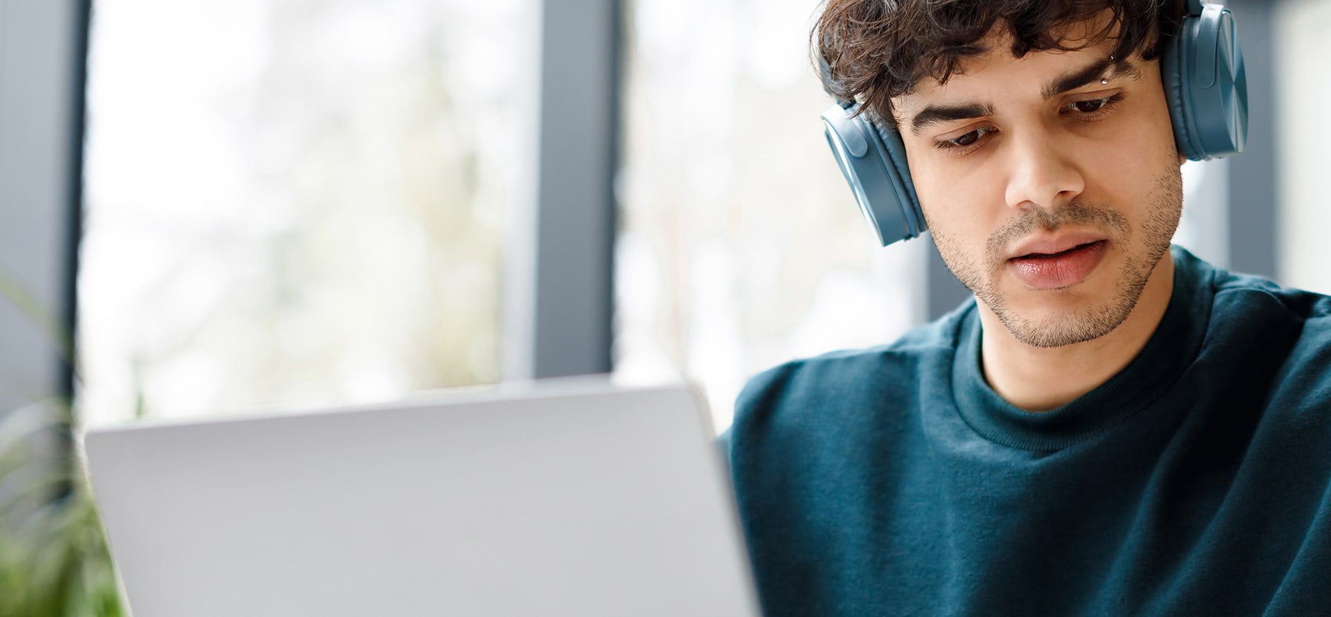 Student with headphones on working on laptop