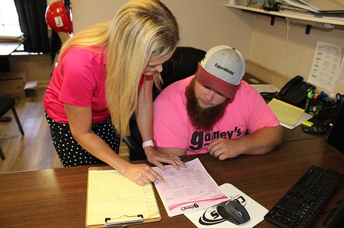 A woman helps a student with paperwork.