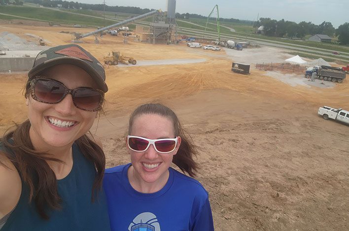 two women in front of a precast plant yard