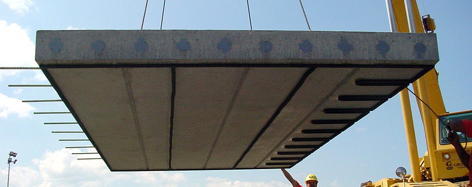 A paving slab is lowered into place on a roadway.