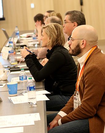 A row of committee members listen intently to the discussion during a meeting.