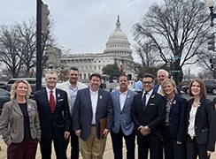 Group photo of professionals outside of a capitol building